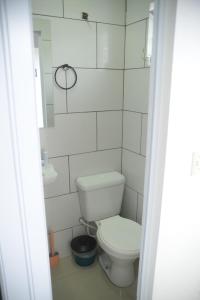 Baño blanco con aseo y espejo en Apartamento a 5 min da praia, en Florianópolis