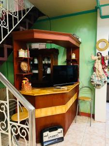 a living room with a tv and a staircase at RJ Apartment in Catbalogan