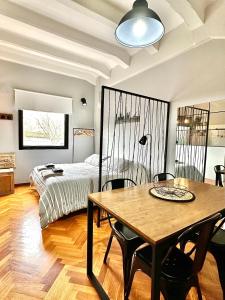 Madero Apartment في بوينس آيرس: غرفة نوم بسرير وطاولة مع كراسي