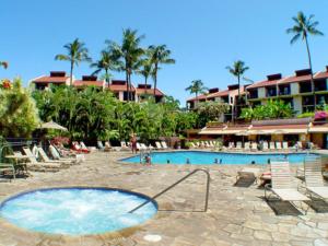 a swimming pool with chairs and people in a resort at Live da HI life--great beach and great views! in Wailea