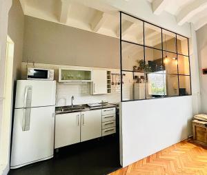 Madero Apartment في بوينس آيرس: مطبخ مع ادوات بيضاء وثلاجة بيضاء