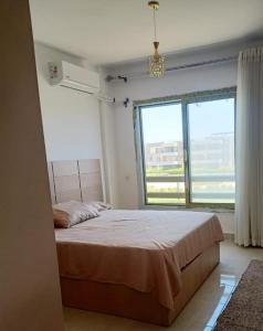 a bedroom with a bed and a large window at Blumar El Sokhna Chalet in Ain Sokhna +59 photos