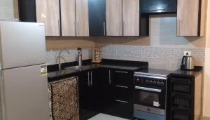 a kitchen with a sink and a refrigerator at Blumar El Sokhna Chalet in Ain Sokhna
