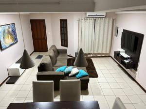 sala de estar con sofá y TV en Las Arecas - rucci 61 en Puerto Iguazú