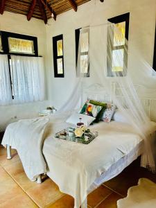 a white bed with a tray of food on it at Villa La Fortuna Altos del Maria in Filipina