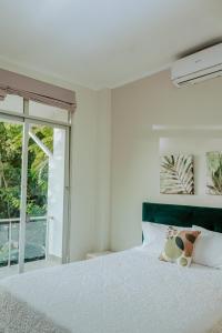 a bedroom with a white bed with a large window at Casa Vista verde in Tarapoto