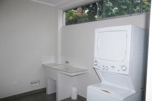 Baño blanco con lavabo y espejo en Casa Vista verde en Tarapoto