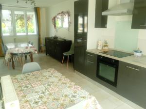 a kitchen with black cabinets and a table and a dining room at Pretty Poppy in Albert