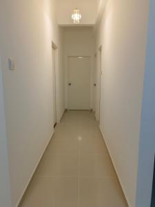 an empty hallway with white walls and white floors at Nasuha Homestay in Sandakan