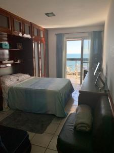 a bedroom with a bed and a view of the ocean at Cobertura Duplex Beira Mar Praia do Morro, Guarapari in Guarapari +37 photos