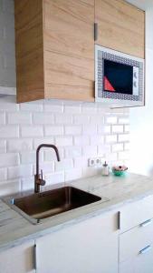 - un comptoir de cuisine avec évier et four micro-ondes dans l'établissement Summer in ALCUDIA with Pool-A/C-WIFI-Netflix..., à Port d'Alcúdia