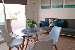- un salon avec une table, des chaises et un canapé dans l'établissement Summer in ALCUDIA with Pool-A/C-WIFI-Netflix..., à Port d'Alcúdia