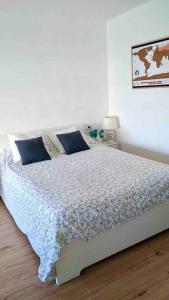 - une chambre avec un lit et des oreillers bleus dans l'établissement Summer in ALCUDIA with Pool-A/C-WIFI-Netflix..., à Port d'Alcúdia