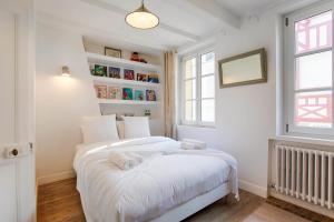 een witte slaapkamer met 2 bedden en een raam bij La Villa Ralph - Beach - Trouville in Trouville-sur-Mer
