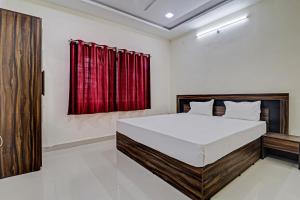 Dhār的住宿－Hotel Midway Treat Dhar，一间卧室配有床和红色窗帘