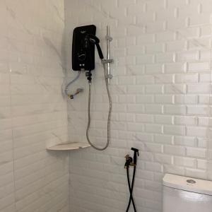 een badkamer met een telefoon aan de muur naast een toilet bij Selesa Hillhomes Cosy House in Bentong