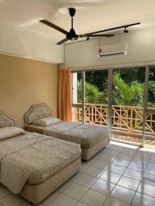 een slaapkamer met 2 bedden en een plafondventilator bij Selesa Hillhomes Cosy House in Bentong