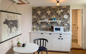 a small kitchen with a table and a microwave at Amazing Apartment In Sommen With Kitchen in Sommen