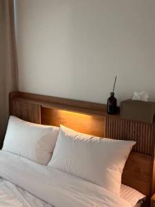 ソウルにあるDanBam Houseのベッド(木製のヘッドボード、白い枕付)