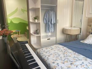 a bedroom with a bed and a dresser next to a piano at Lu Luxury Homestay et Apartment - Vinhomes Smart City Hanoi in Hanoi