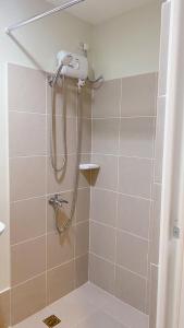 a shower with a shower head in a bathroom at Luxury Suites at Brenthill Baguio City in Baguio +80 photos