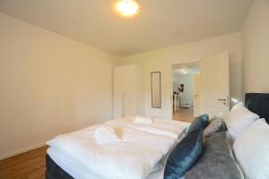 a large white bed in a room with a couch at Apartment am Hafen in Schleswig