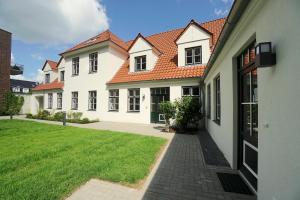 a large white house with a grass yard at Apartment am Hafen in Schleswig