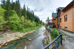 ein Fluss neben einem Gebäude neben einem Haus in der Unterkunft LAVANDA country club in Tatariw