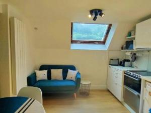 un salon avec un canapé bleu dans une cuisine dans l'établissement Duplex 2 pièces près des télécabines avec parking, idéal pour 4 personnes - FR-1-234-307, à Cauterets
