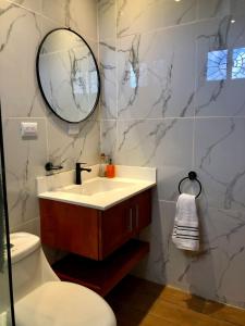 een badkamer met een wastafel, een spiegel en een toilet bij Low Tide - Popoyo Aparts in Popoyo