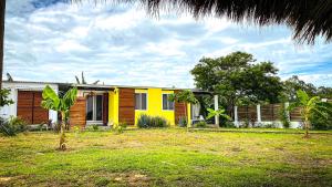 een geel huis in een tuin met bij Low Tide - Popoyo Aparts in Popoyo