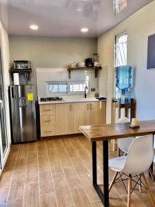 a kitchen with a table and a refrigerator at Low Tide - Popoyo Aparts in Popoyo