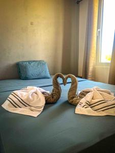 twee handdoeken in de vorm van een hart op een bed bij Low Tide - Popoyo Aparts in Popoyo
