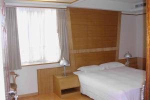 a bedroom with a white bed and a window at Jia Yun Business Hotel in Yongkang