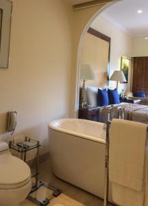 a bathroom with a bath tub and a bed at The Oberoi Bengaluru in Bengaluru