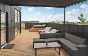 patio con divano e tavoli su una terrazza di 5 Bedroom Pet Friendly Home In Brkop a Hvidbjerg