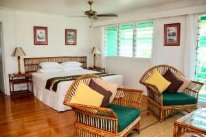 a bedroom with a bed and two chairs at Nukubati Great Sea Reef in Nukubati