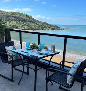 - Balcón con mesa y sillas y vistas a la playa en Cobertura Duplex Beira Mar Praia do Morro, Guarapari, en Guarapari