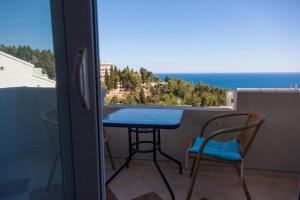 un tavolo e sedie su un balcone con vista sull'oceano di L&I Villa a Ulcinj