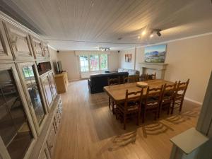 een woonkamer met een houten tafel en stoelen bij Cosy-Cottage in Hechtel-Eksel