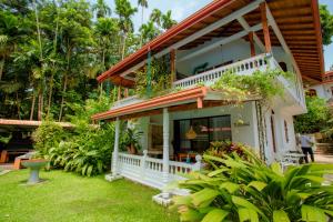 uma casa com um alpendre com plantas em Ayubowan Swiss Lanka Bungalow Resort em Bentota