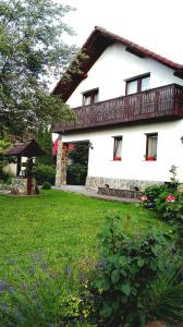 a white house with a balcony on top of a yard at Studio 45 sqm with mountain view in Porumbacu de Sus