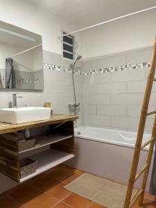 une salle de bain avec un lavabo, une baignoire et un miroir dans l'établissement Studio Anse des Rochers, à Saint-François
