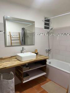 une salle de bains avec lavabo, miroir et baignoire dans l'établissement Studio Anse des Rochers, à Saint-François 10 autres photos