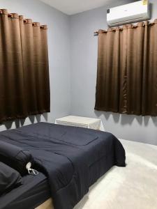 Ban Tha Nam Tun的住宿－Walai House วลัยเฮ้าส์ กาญจนบุรี，一间卧室配有蓝色的床和棕色窗帘