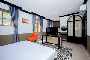 富国SUNSET BAY RETREAT的一间带床、书桌和电视的卧室