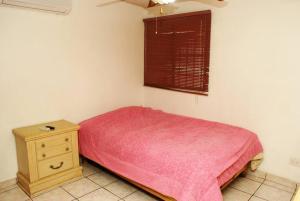 um pequeno quarto com uma cama e uma mesa de cabeceira em Encantadora casa con 3 habitaciones frente al parque em Hermosillo