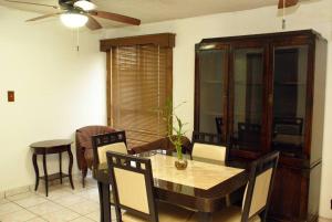 uma sala de jantar com uma mesa e cadeiras e uma ventoinha de tecto em Encantadora casa con 3 habitaciones frente al parque em Hermosillo