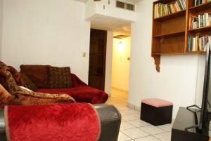 sala de estar con sofá rojo y estante para libros en Encantadora casa con 3 habitaciones frente al parque, en Hermosillo