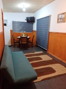 a living room with a blue couch and a table at Cabaña muy cómoda cerca de Saltos del Laja in Cabrero